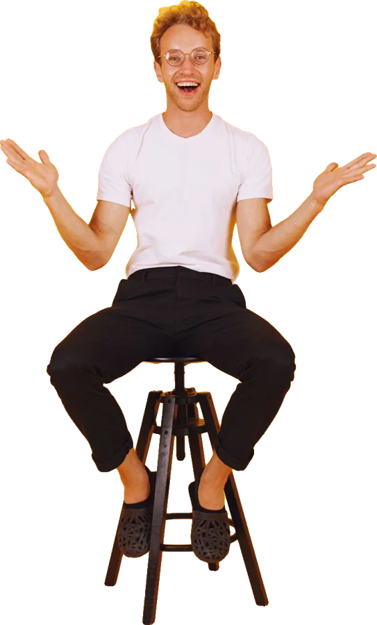 Un homme sur un tabouret ouvre grand les bras, ravi