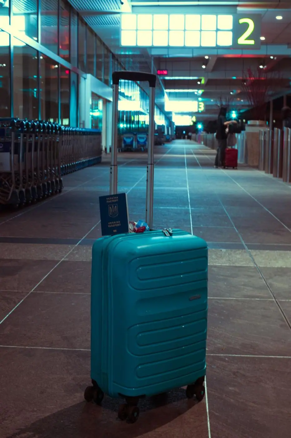Une valise turquoise dans un hall d'aéroport