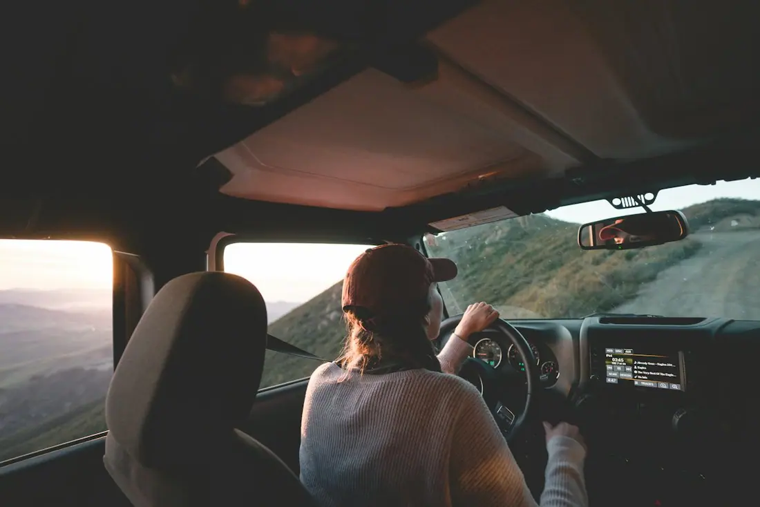 Femme au volant sur une route côtière